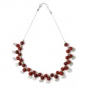 Collier en billes de verre rouge prolong&eacute;es de spirales en m&eacute;tal mont&eacute;es sur cha&icirc;ne. 